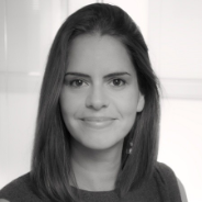 A grey-scaled photo of a woman smiling at the camera.